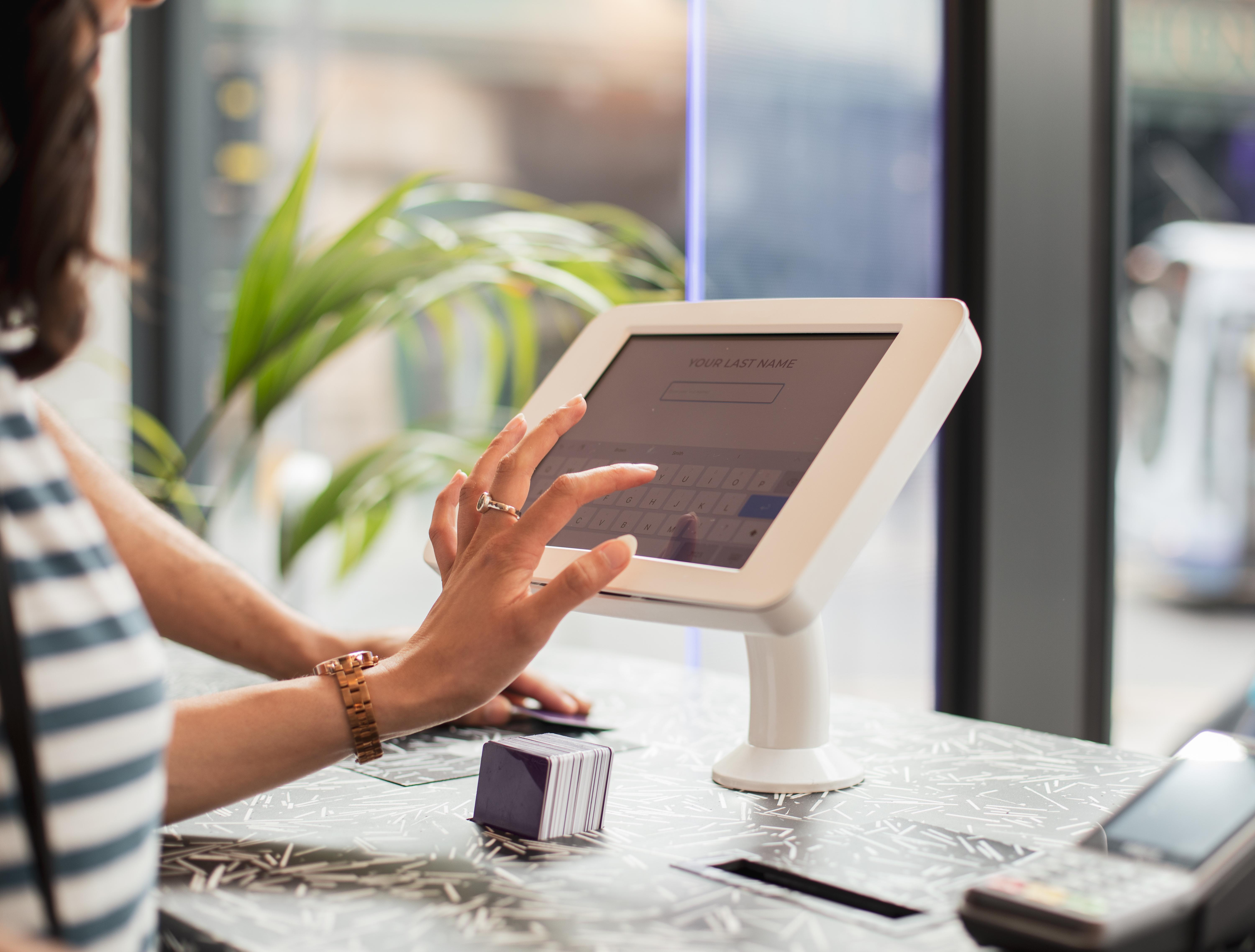 Yotel Glasgow Exterior foto A woman using a tablet to enter her name at a check-in desk